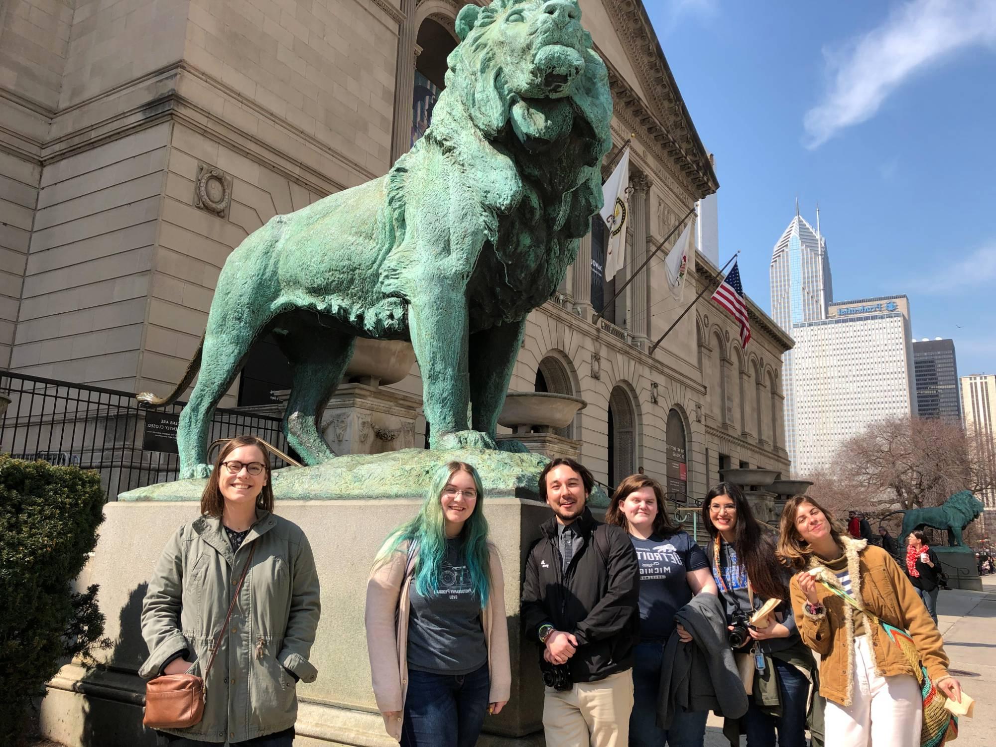 Group of students gathered at the Art Institute by the lion.